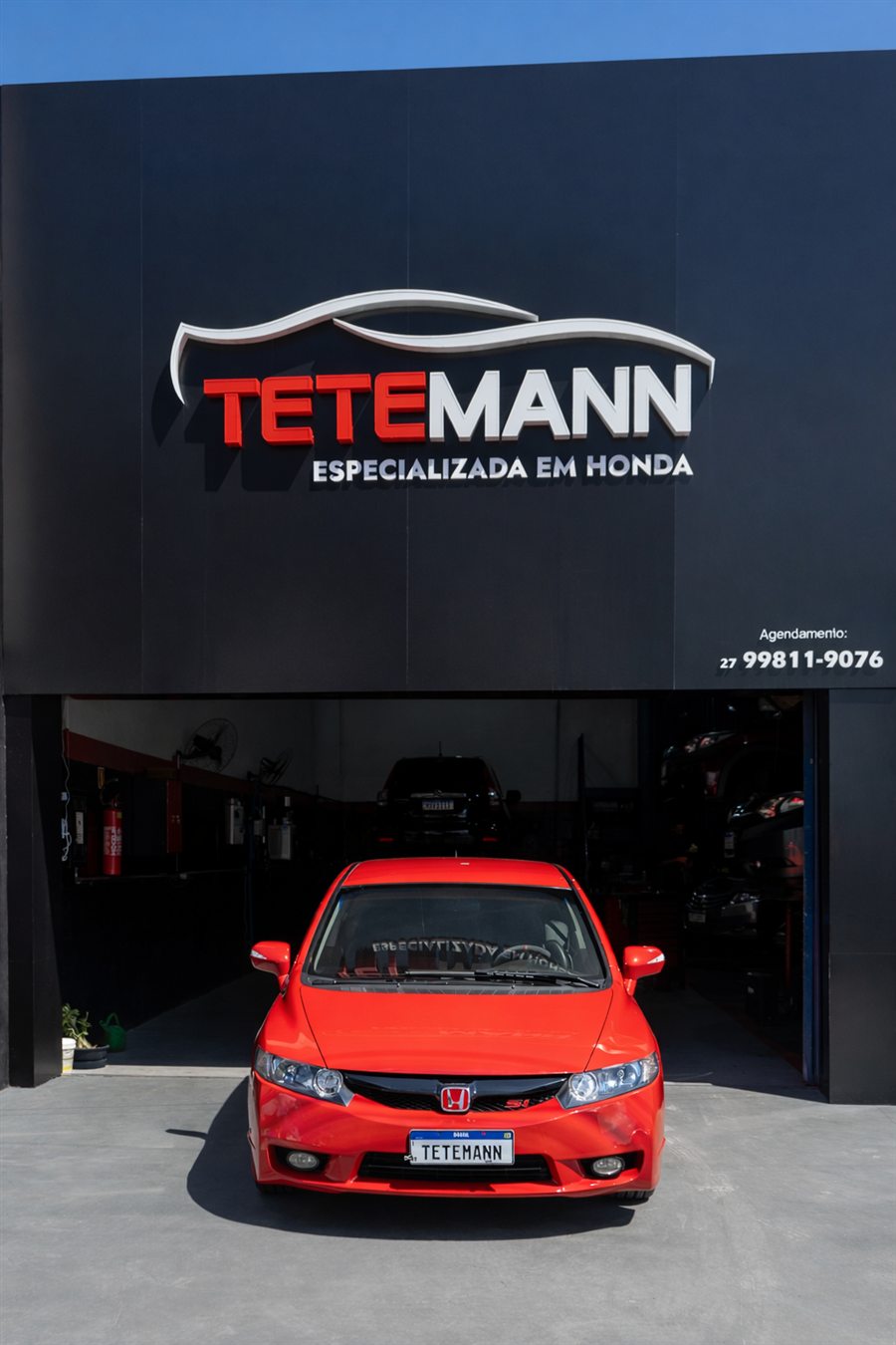 Fachada atual da oficina Tetemann, especializada em Honda, em Serra/ES, com um Honda Civic vermelho na entrada