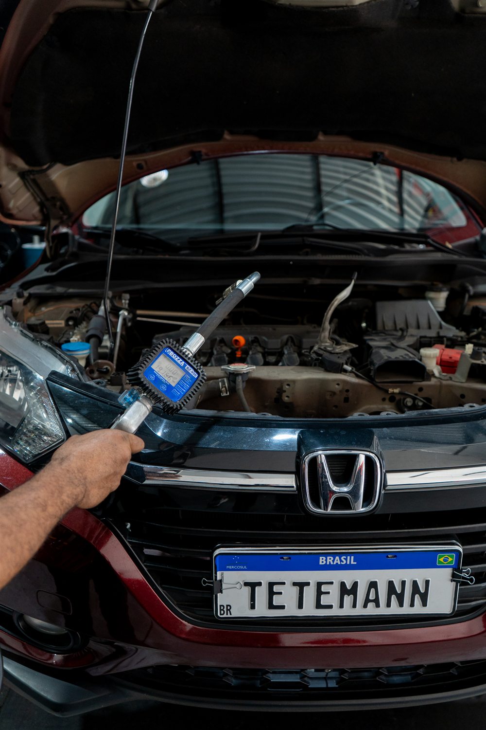Mecânico da Tetemann medindo o óleo do motor de um Honda HR-V com equipamento de precisão